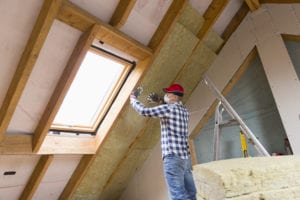 A Man Installs Blown Insulation in an Attic in Toronto, ON